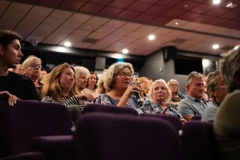A woman in the audience speaking into a microphone