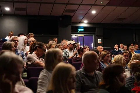 People talking among the seats in the auditorium