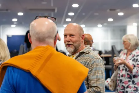 Two men in conversation in the foyer, seen at close range
